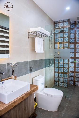a bathroom with a white toilet and a sink at Sơn Hà Hotel in Quy Nhon