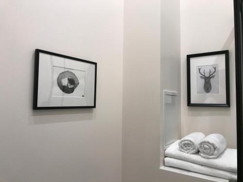 a bathroom with two pictures on the wall and towels at Cozy Home Valdemara, free parking, self check-in in Rīga