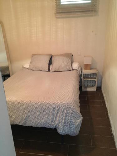 a bed in a small room with a window at T3 proche Castillet in Perpignan