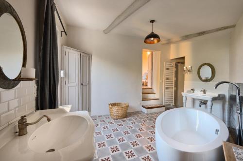 a white bathroom with a tub and a sink at Maison Lou Roucas in Cabrières-dʼAigues