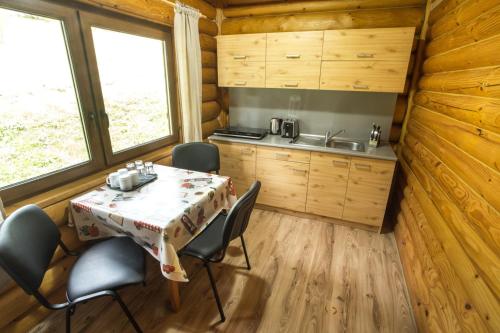 una cocina y comedor en una cabaña de madera con mesa y sillas en Ubytovanie Dobšinská Ľadová Jaskyňa en Stratená