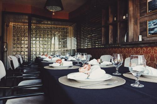 a long table in a restaurant with plates and wine glasses at Hotel Solaris in São Miguel dʼOeste