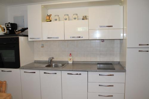 een keuken met witte kasten en een spoelbak bij Apartment Frleta in Umag