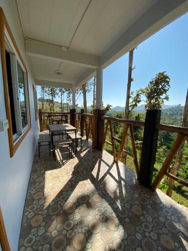 a screened in porch with a table and chairs on it at One khaokho homestay in Khao Kho