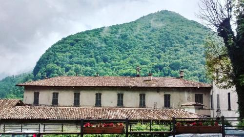 a building in front of a mountain with a house at Ostello Sociale Borgo Venno in Lavenone