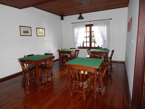 a dining room with green tables and chairs at Hotel Aldeia da Serra in Campos do Jordão