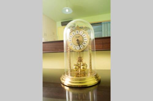 a clock in a glass dome on a table at Modern Luxury Villa with Pool, just 5min to sea in Kalamata