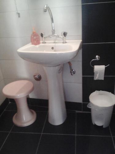 a bathroom with a white sink and a toilet at HERMOUPOLI ROOMS in Ermoupoli