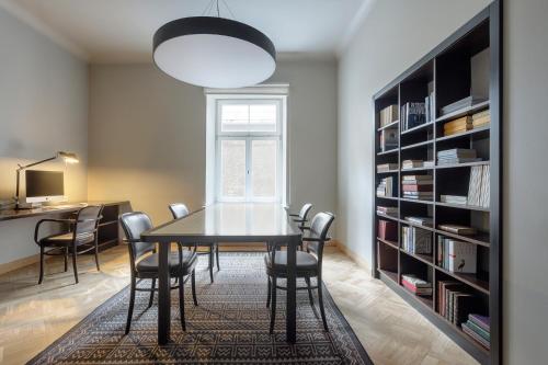 a dining room with a table and chairs and a book shelf at Neiburgs Hotel in Rīga