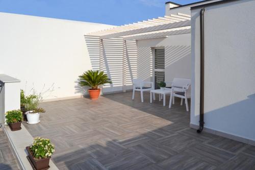 a patio with chairs and a table on a building at Quattroquarti Stradivari Home in Noto