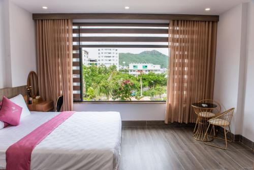 a bedroom with a bed and a large window at Sơn Hà Hotel in Quy Nhon