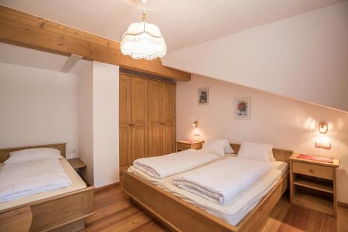 a bedroom with two beds and a chandelier at Apartment Kornblume - Mesnerhof in Sand in Taufers