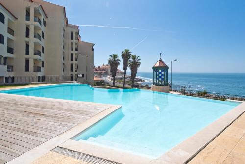 a swimming pool with a view of the ocean at Sea Front Family Apartment in Parede