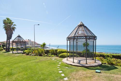 a gazebo in a park next to the ocean at Sea Front Family Apartment in Parede
