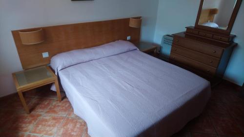 a bedroom with a white bed and a wooden headboard at Montes de Alvor - Bloco C-1-10 in Alvor