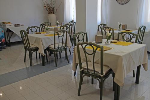 a dining room with tables and chairs with yellow napkins at Hotel Del Porto in Palau