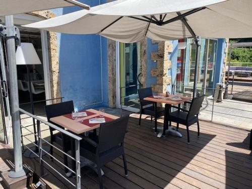 two tables and chairs under an umbrella on a deck at Casino Circus d'Allevard in Allevard