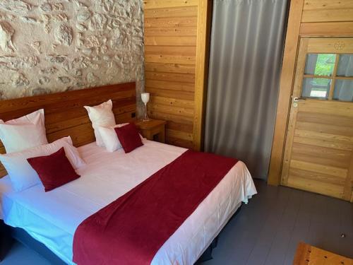 a bedroom with a large bed with red and white pillows at Casino Circus d'Allevard in Allevard