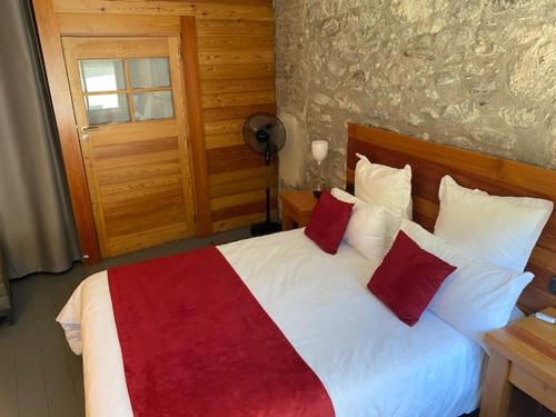 a bedroom with a bed with red and white pillows at Casino Circus d'Allevard in Allevard
