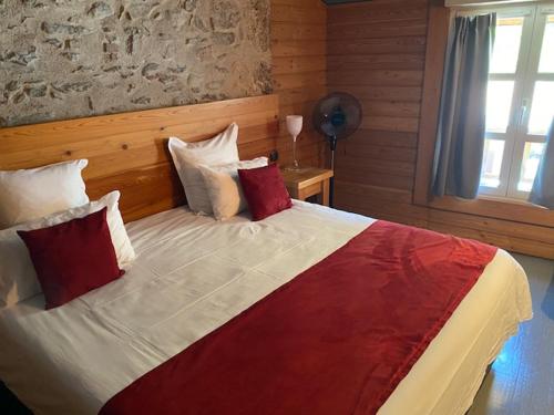 a bedroom with a large bed with red and white pillows at Casino Circus d'Allevard in Allevard