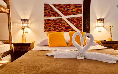 um quarto com uma cama com duas toalhas brancas em Vila Pequeá Pousada Ilhabela em Ilhabela