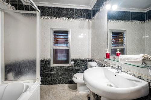 a bathroom with a white sink and a toilet at Hotel Gines in Ginés