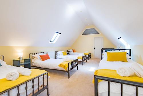 a attic room with four beds in it at Great Higham Barn by Bloom Stays in Canterbury