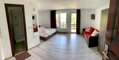 - un couloir avec un salon doté d'un canapé rouge dans l'établissement Casa Flori de Sare, à Slănic