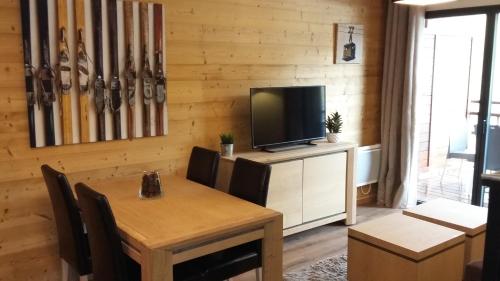 uma sala de jantar com uma mesa e uma televisão em T2 cabine vue montagne Valnéa Peyragudes em Germ