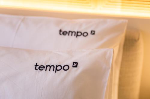 two white shirts with the word tempo on them at Tempo FLH Hotels Lisboa in Lisbon