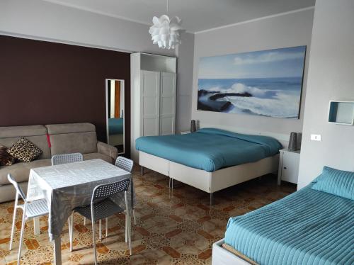 a bedroom with a bed and a couch and a table at B&B Residenza Leonardo in Falconara Marittima