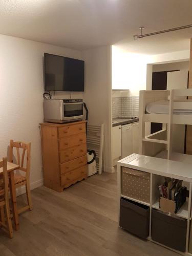 Cette petite chambre comprend un lit et une télévision sur une commode. dans l'établissement Studio tout confort avec vue sur les sommets, à Combloux
