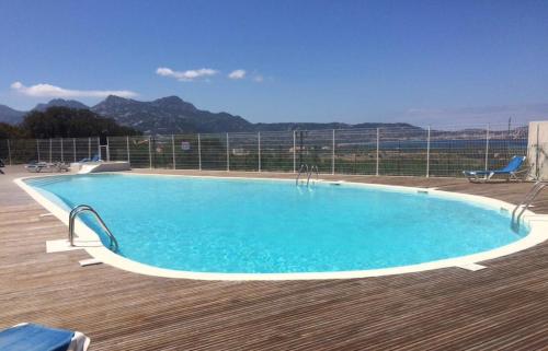 a swimming pool on a deck with mountains in the background at Appartamento Mirella con piscina in Lumio