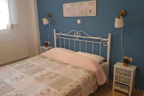 a bedroom with a bed and a blue wall at Zefis Appartment in Ouranoupoli