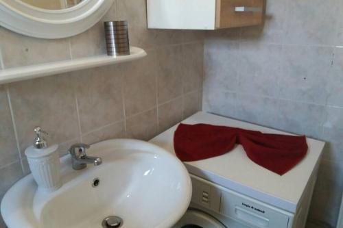 a bathroom with a sink and a toilet with a red bow at Zefis Appartment in Ouranoupoli