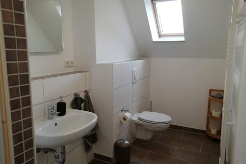 a bathroom with a white toilet and a sink at Ferienhaus im Grünen in Brunshausen