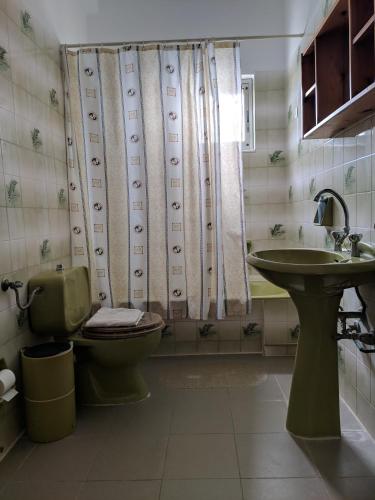 a bathroom with a toilet and a sink at Oasis Apartments in Stoupa