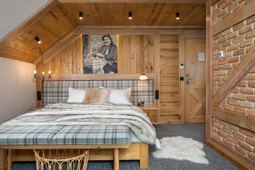 a bedroom with a bed and a brick wall at Zara Chalet in Bran