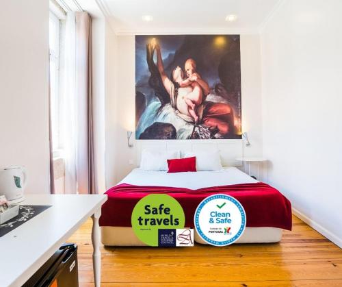 a bedroom with a bed with a painting on the wall at Lisbon Arsenal Suites in Lisbon