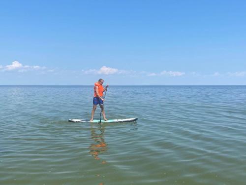 un homme debout sur une planche de paddle dans l'eau dans l'établissement Järve Holiday Village, à Kodavere