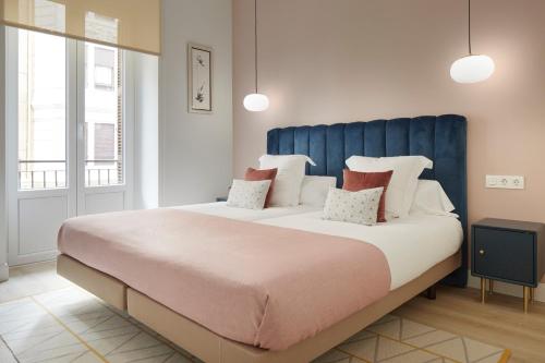 een groot bed met een blauw hoofdeinde in een kamer bij Pikatxia by FeelFree Rentals in San Sebastian