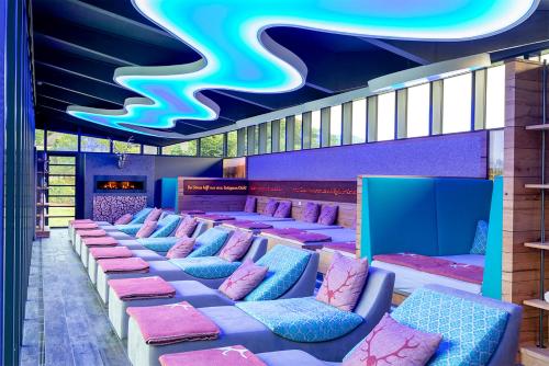 a row of chairs in a room with purple and pink at Hotel Heselbacher Hof in Baiersbronn