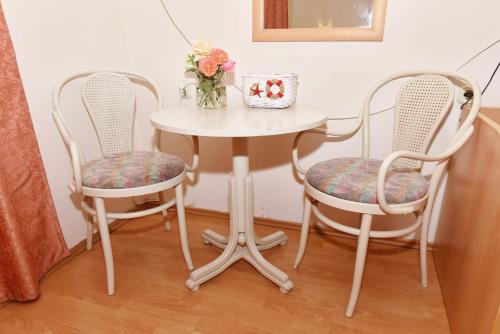 two chairs and a white table with a table and two chairs at Villa Lucija in Ohrid