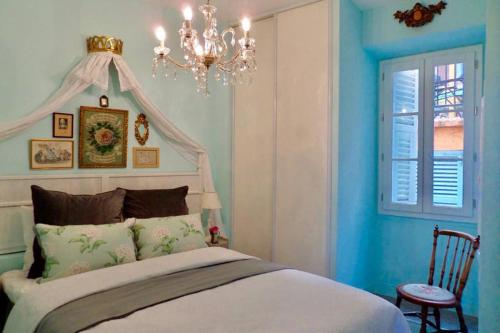 a bedroom with a bed and a chandelier at CHARMANT HOME - Mariesol in Nice