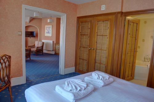 a hotel room with a bed with towels on it at The Orwell Hotel in Felixstowe