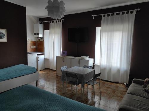 a living room with a table and a kitchen at B&B Residenza Leonardo in Falconara Marittima