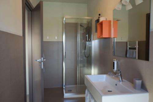 a bathroom with a shower and a white sink at Foresteria La Merlina in Borgo Adorno