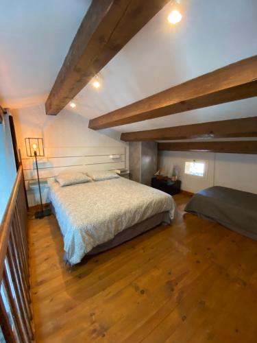 een slaapkamer met een groot bed en een houten vloer bij Appartement Les grands pins in Les Issambres