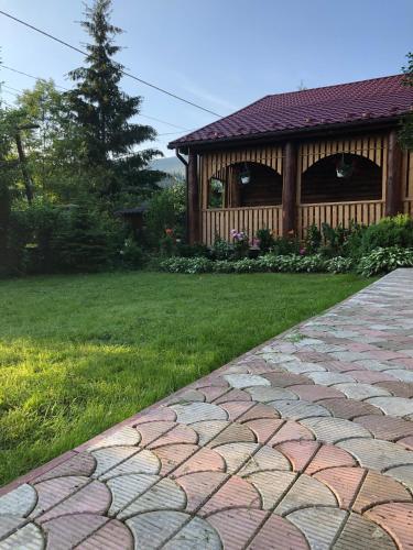 a stone walkway in front of a house at Skarbivka in Vorokhta