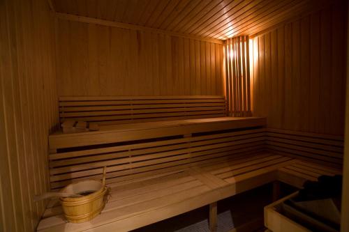 a small wooden sauna with a bucket in it at Ramada Hotel & Suites by Wyndham Bucharest North in Bucharest